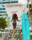Woman in Brown Bikini Standing on Blue Towel