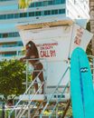 Smiling Woman in Bikini Standing on Lifeguard Tower on City Beach