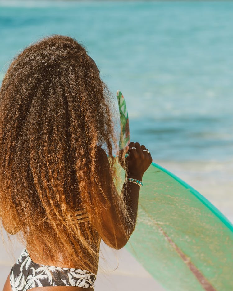 Woman On A Beach Holding A Surfboard