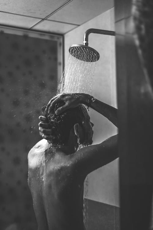Grayscale Photo of Man Taking a Shower