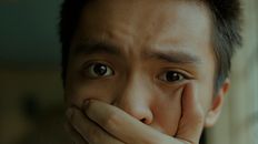 一名年轻人捂着嘴，一脸痛苦