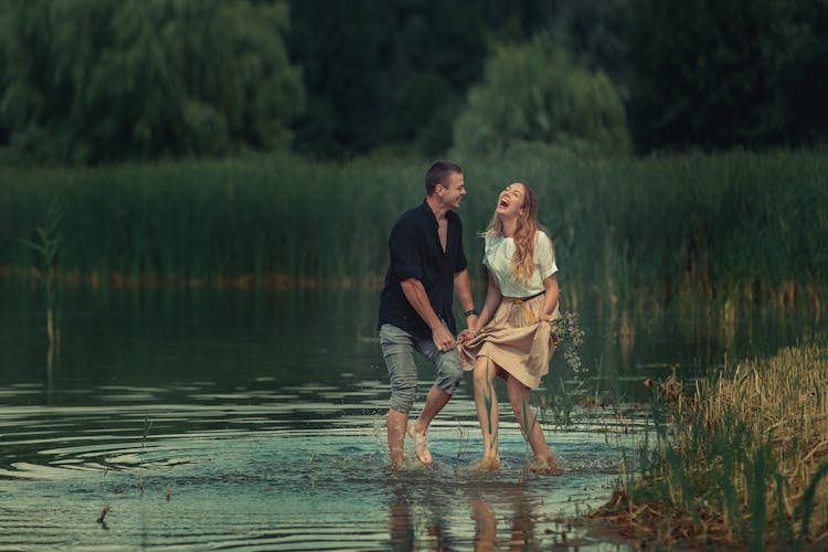 Couple Walking Through Shallow Water Laughing