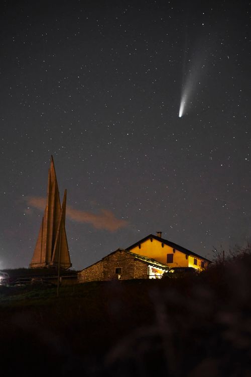 Free A dramatic night sky with a bright comet over a house in Asiago, Italy. Stock Photo