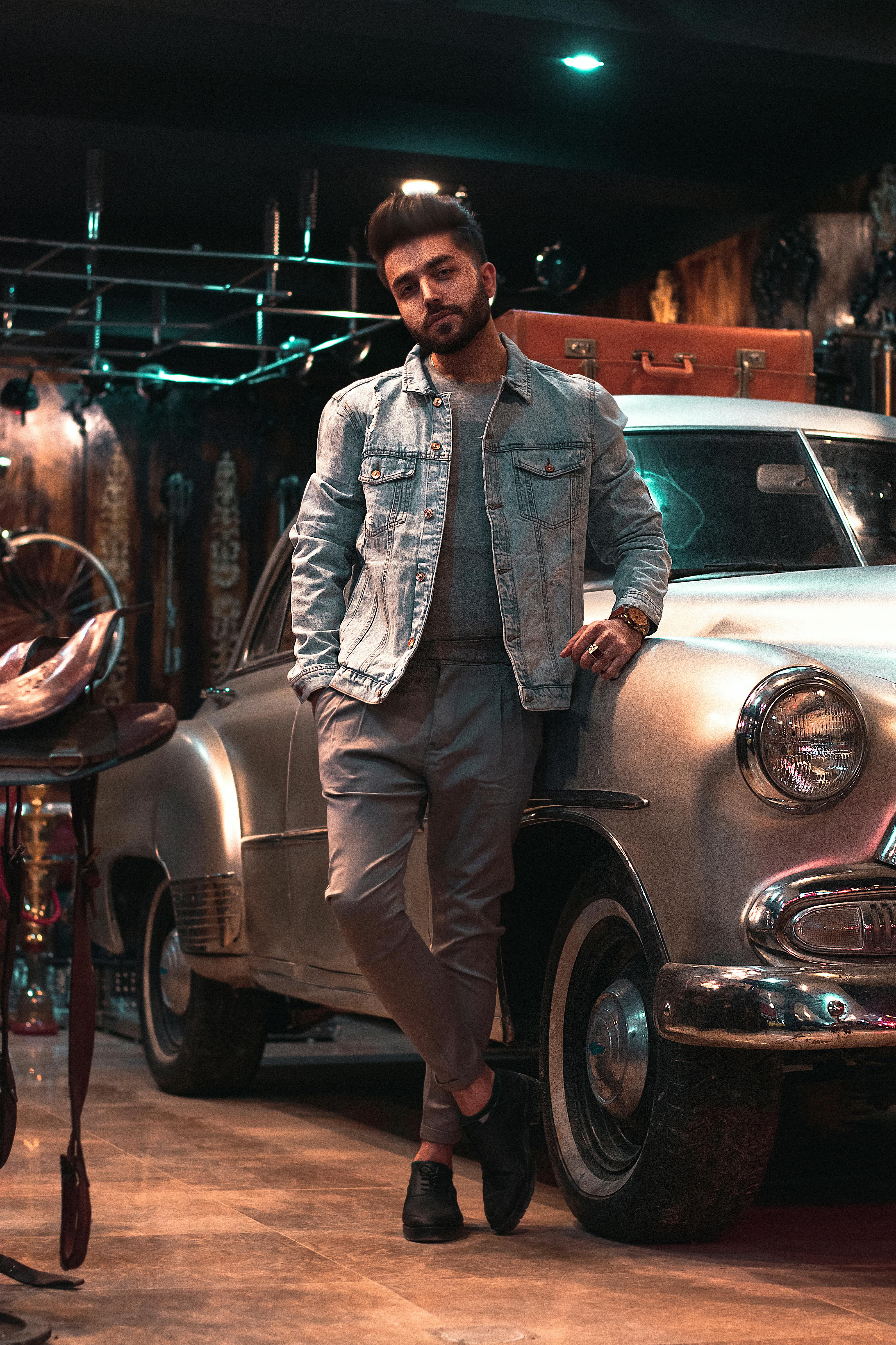 Male model posing leaning on hood of an old rusted car in scrap yard Stock  Photo - Alamy