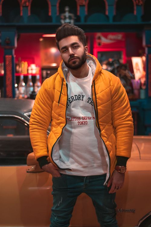 Free Stylish young man in New York City posing by a vintage car in casual fashion. Stock Photo