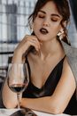 Alluring young lady chilling in restaurant with wineglass