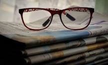 Eyeglasses on Top of Newspapers