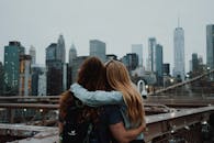 在布鲁克林大桥上，一对夫妇相拥，背景是纽约市的天际线