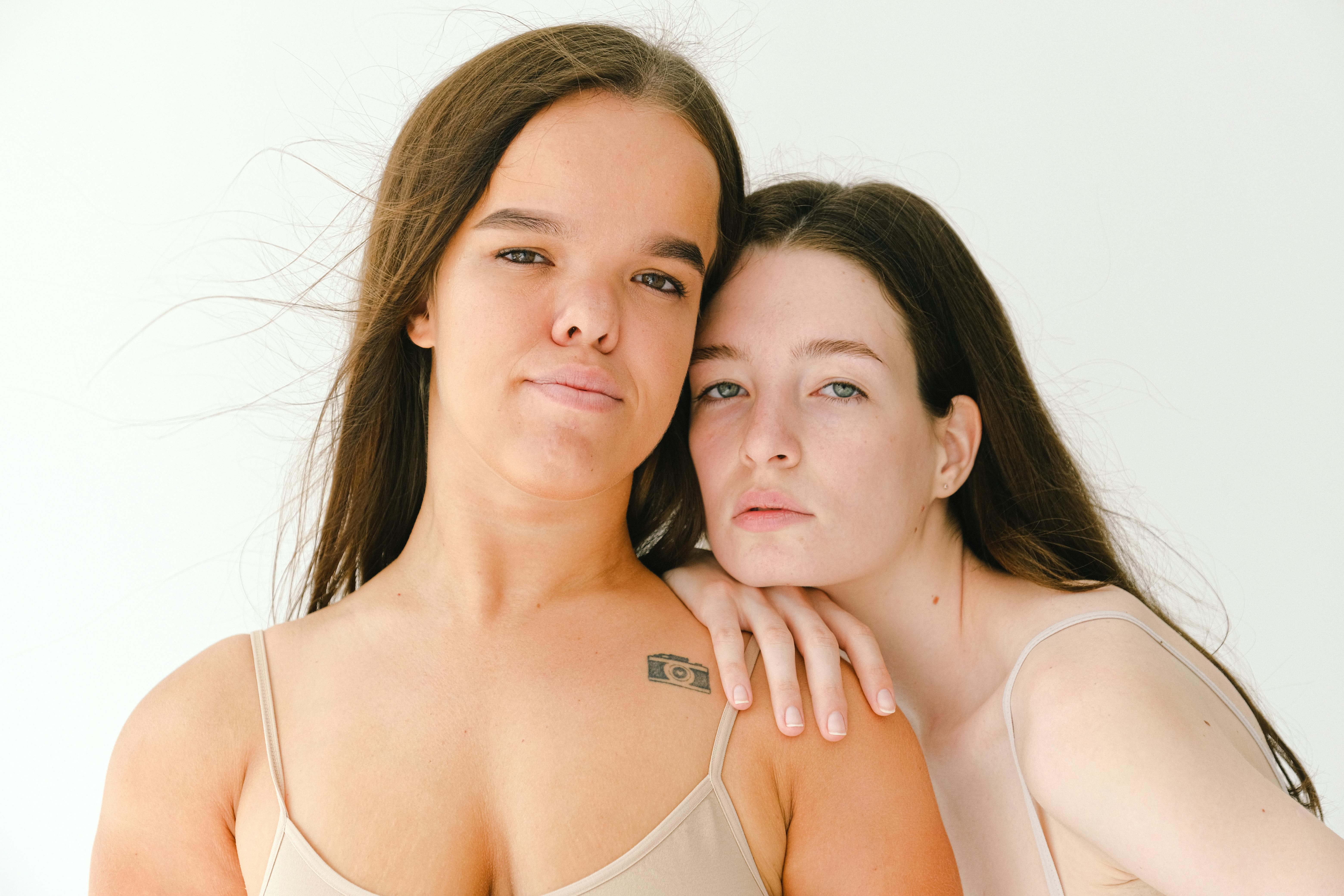 two women wearing nude color top