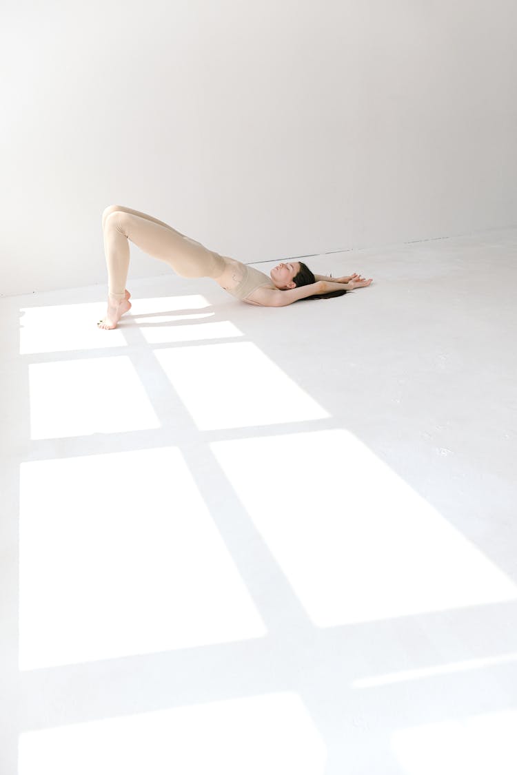 Flexible Slim Woman Doing Bridge Yoga Asana On Toes In Sunny Studio