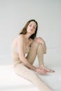 Slim woman sitting on floor in studio