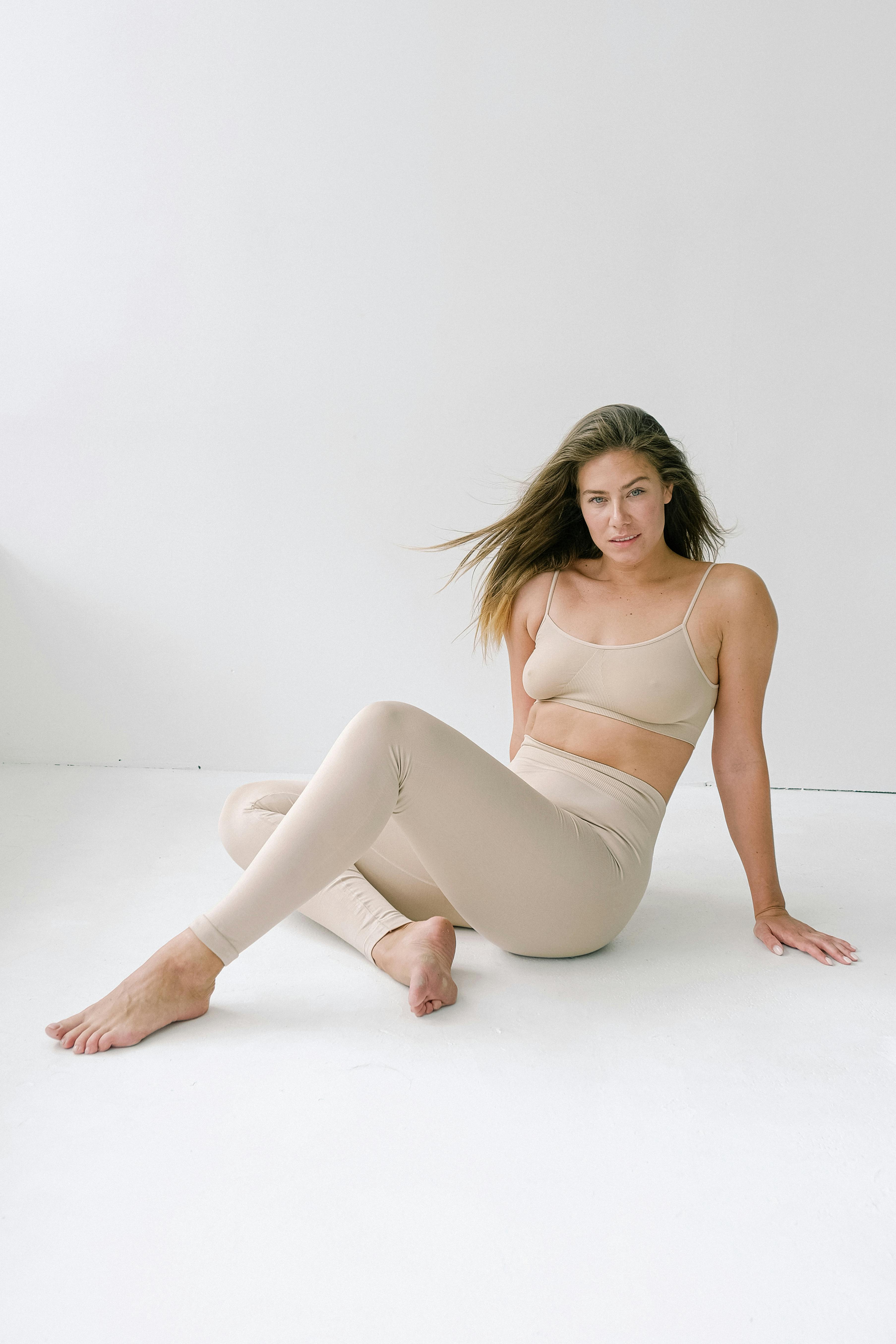 Slim woman sitting on floor in studio · Free Stock Photo