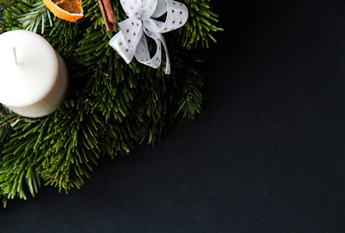 White Ribbons and Candle on Green Pine Tree