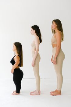 三位身高不一的女性身着运动服，象征着多样性和身体积极性