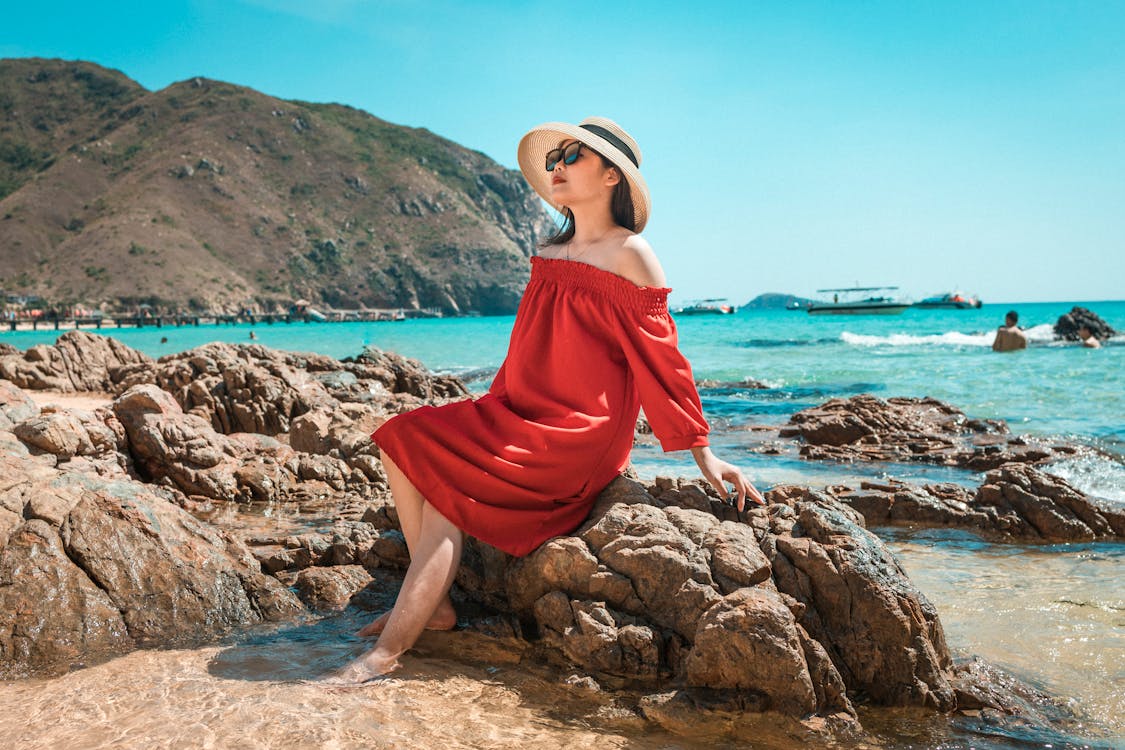 Stylish woman sitting on stone