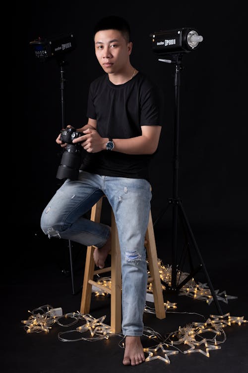 Ethnic photographer sitting on stool