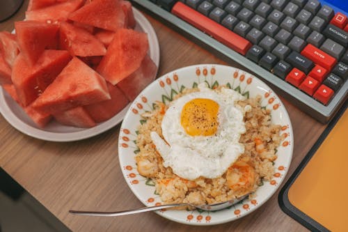 Free Fried Egg on Fried Rice and a Plate of Sliced Watermelon Stock Photo