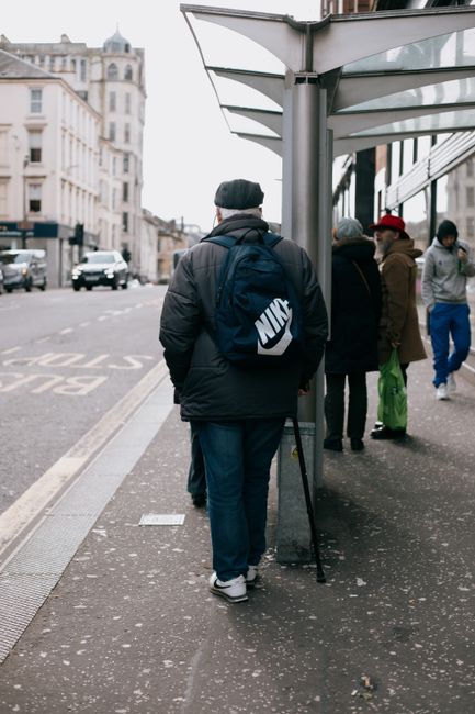 Urban street scene in Glasgow showing people waiting at a bus stop.