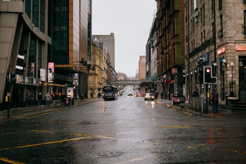 Vehicles Driving on Wet Asphalt Road in a City