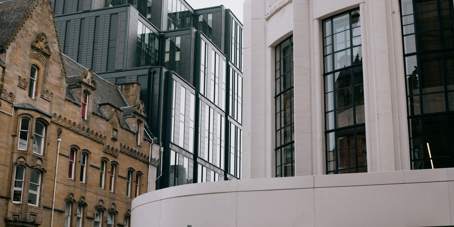 A blend of modern and Victorian architecture in Glasgow, Scotland, showcasing urban contrast.