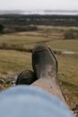 Person in Blue Denim Jeans and Brown Leather Boots Sitting on Grass Field