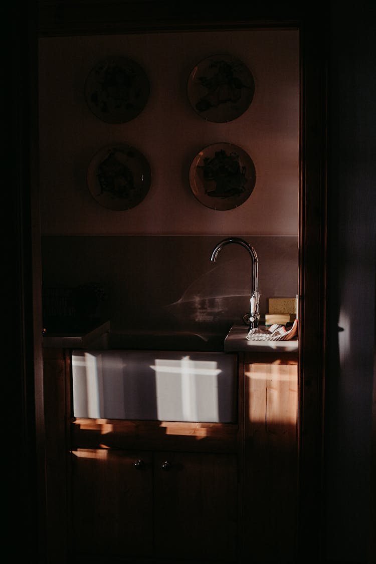 Decorative Plates Hanging On The Wall Over A Sink