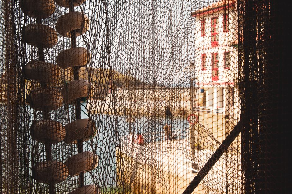 Close-up of fishing nets with a view of Cudillero harbor in Asturias, Spain.