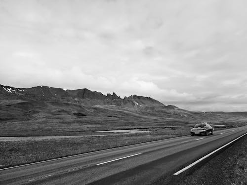 Automobile driving through mountainous countryside on cloudy day