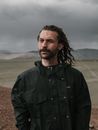 Portrait of a Man with Stubble and Long Hair Under a Stormy Sky 
