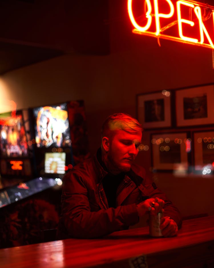 A Man Opening A Can Of Beer In A Pub