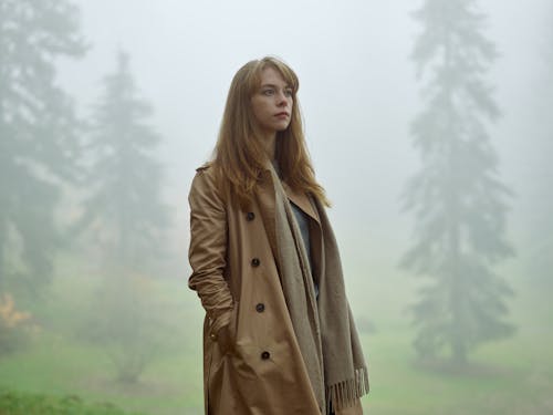 Woman Standing in Misty Forest