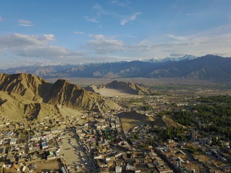 A breathtaking aerial view of Leh city with the majestic Himalayas in the background, showcasing natural beauty.