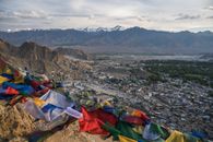 Assorted Color Textiles on Green Grass Field Near Mountain