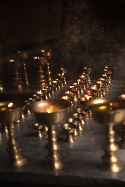 Free Rows of burning candles in decorative brass stands cast a warm glow. Stock Photo