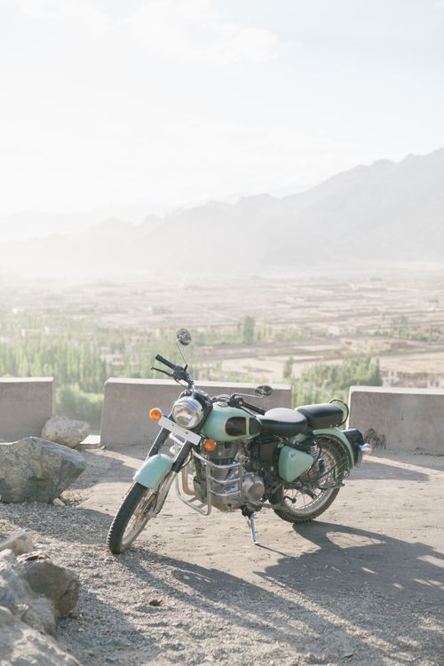 Free Vintage motorcycle parked with a stunning view of the mountains under clear skies. Stock Photo