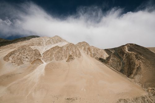 Free Low angle view of rugged mountain peaks against a dramatic cloud-filled sky. Stock Photo