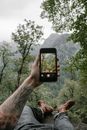 Man Taking a Photo of a Mountain Landscape