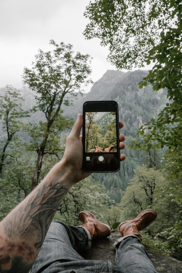 Man Taking A Photo Of A Mountain Landscape