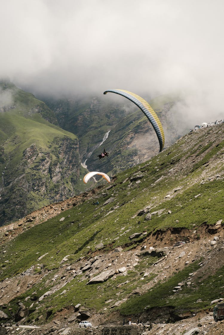 Person Paragliding Above The Mountain Slope