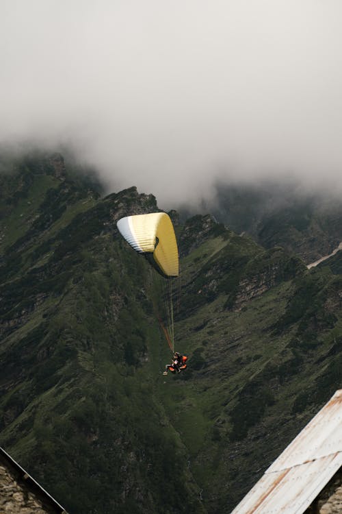 Free Yellow Hot Air Balloon over Green Mountains Stock Photo