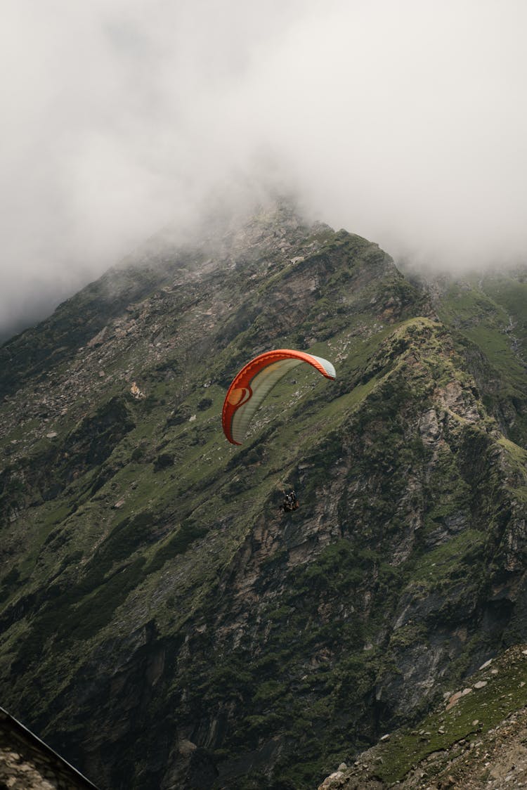 Person Paragliding Over A Mountain