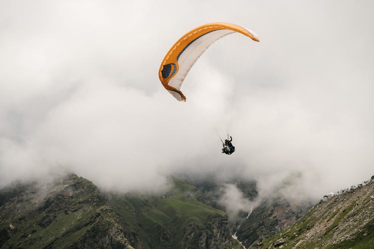 People Paragliding Above A Mountain