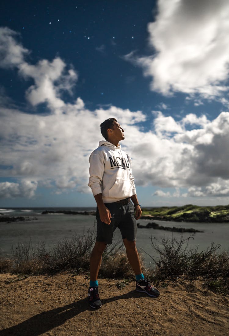 Young Man In White Sweatshirt On Sandy Coast