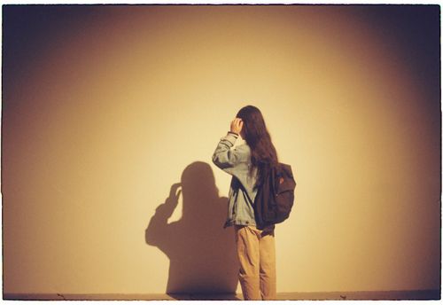 Free A person stands against a wall, casting a shadow under warm lighting in Hanoi. Stock Photo