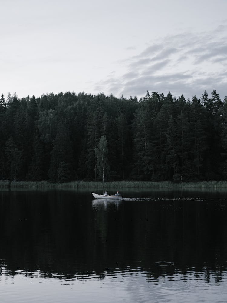 People On A Wooden Boat Cruising A Lake