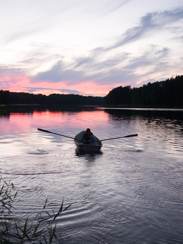 Friends On A Boat Cruising A Lake During Sunset