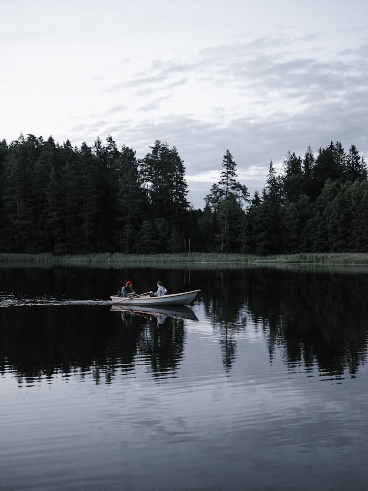 Friends On A Wooden Boat Cruising A Lake