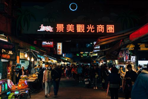 Free Vibrant scene of a busy night market in Taipei with bright lights and crowds. Stock Photo