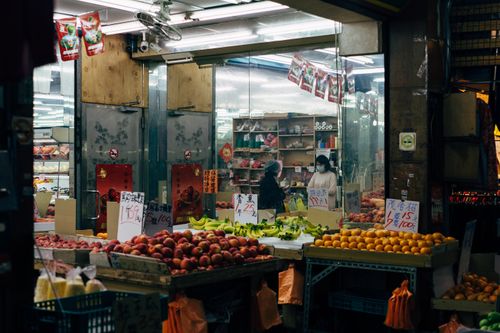 Free Vibrant Asian market scene featuring fresh produce, fruits, and daily shopper interactions. Stock Photo