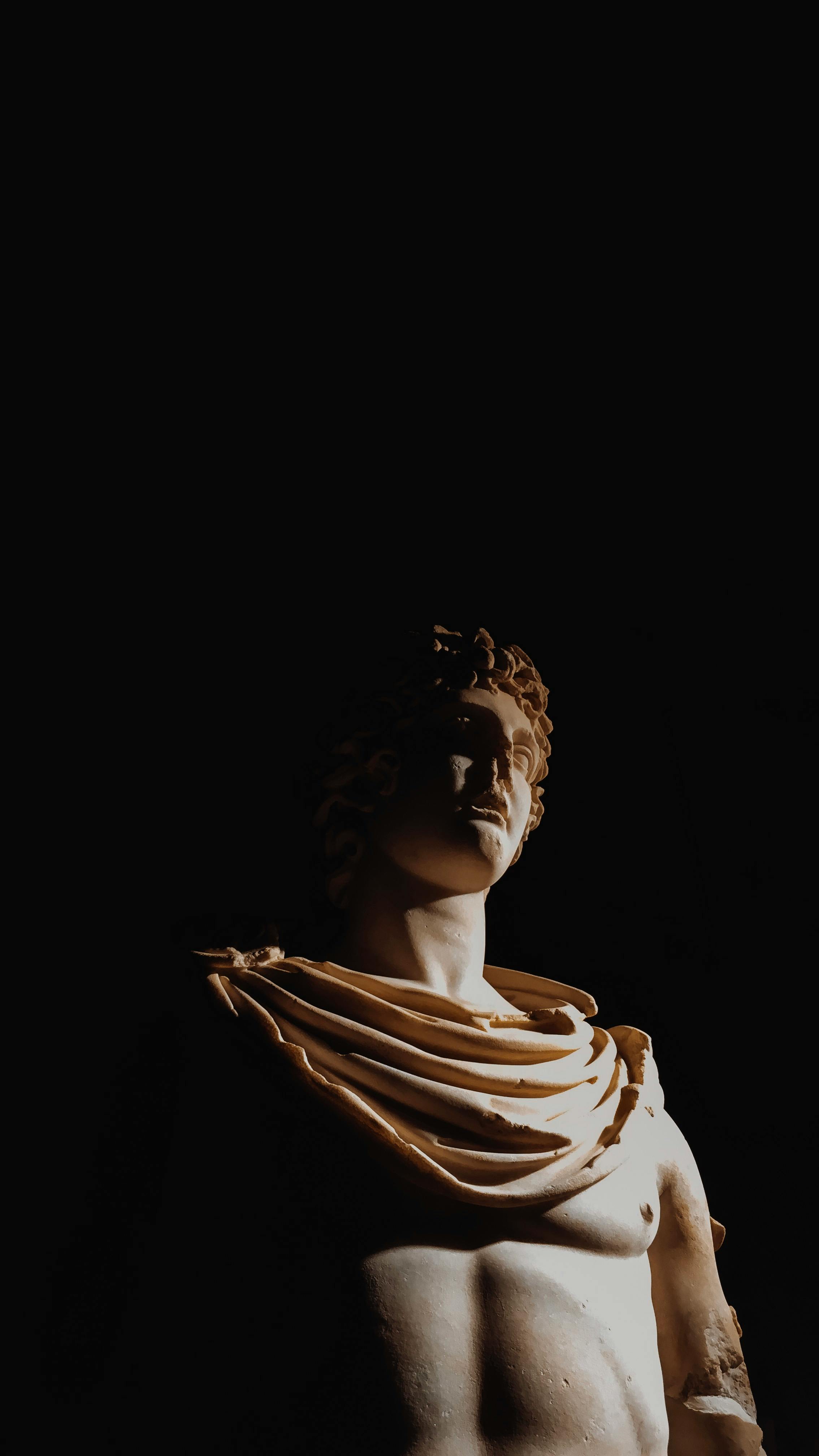 Statue of ancient character placed in deep shadow · Free Stock Photo